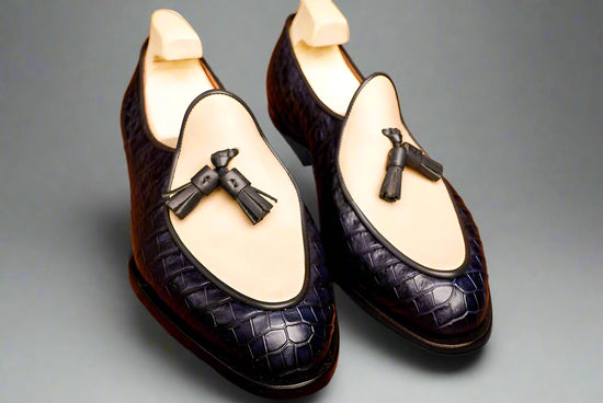 Pair of black loafers with decorative elements on a wooden surface