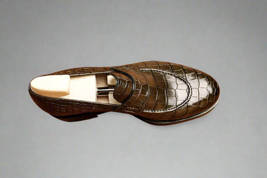 Brown leather shoe on a wooden surface