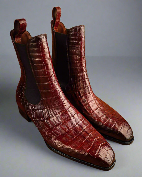 Pair of brown crocodile-textured boots on a wooden surface