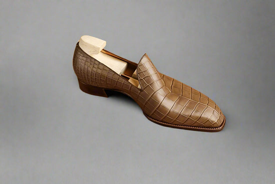 Brown textured loafer shoe on a wooden surface