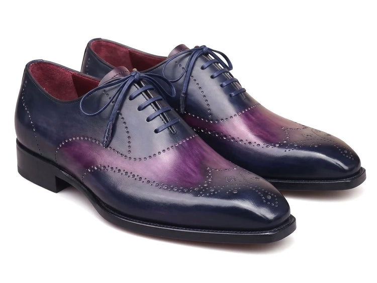 A pair of men's wingtip oxford shoes featuring a glossy dark blue and purple gradient finish, with matching blue laces, shown on a plain white background.