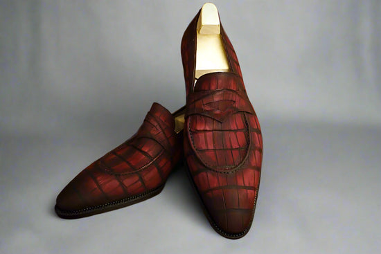 Pair of red plaid loafers on a wooden surface