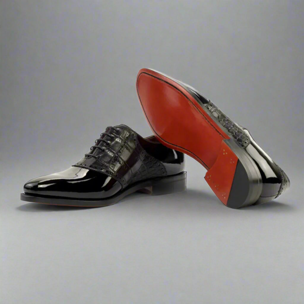 Black dress shoes with a red sole on a white background