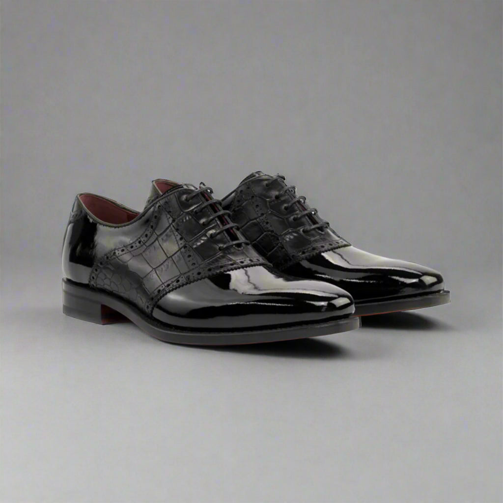 Pair of black patent leather dress shoes on a white background
