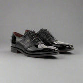 Pair of black patent leather dress shoes on a white background