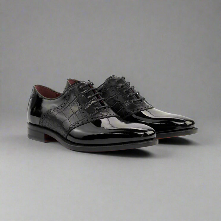 Pair of black patent leather dress shoes on a white background