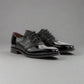 Pair of black patent leather dress shoes on a white background