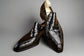 Pair of black crocodile-patterned loafers on a wooden surface