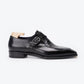A black double monk strap leather shoe with a toe cap featuring a crocodile-embossed pattern, displayed on a light wood shoe tree against a clean white background.