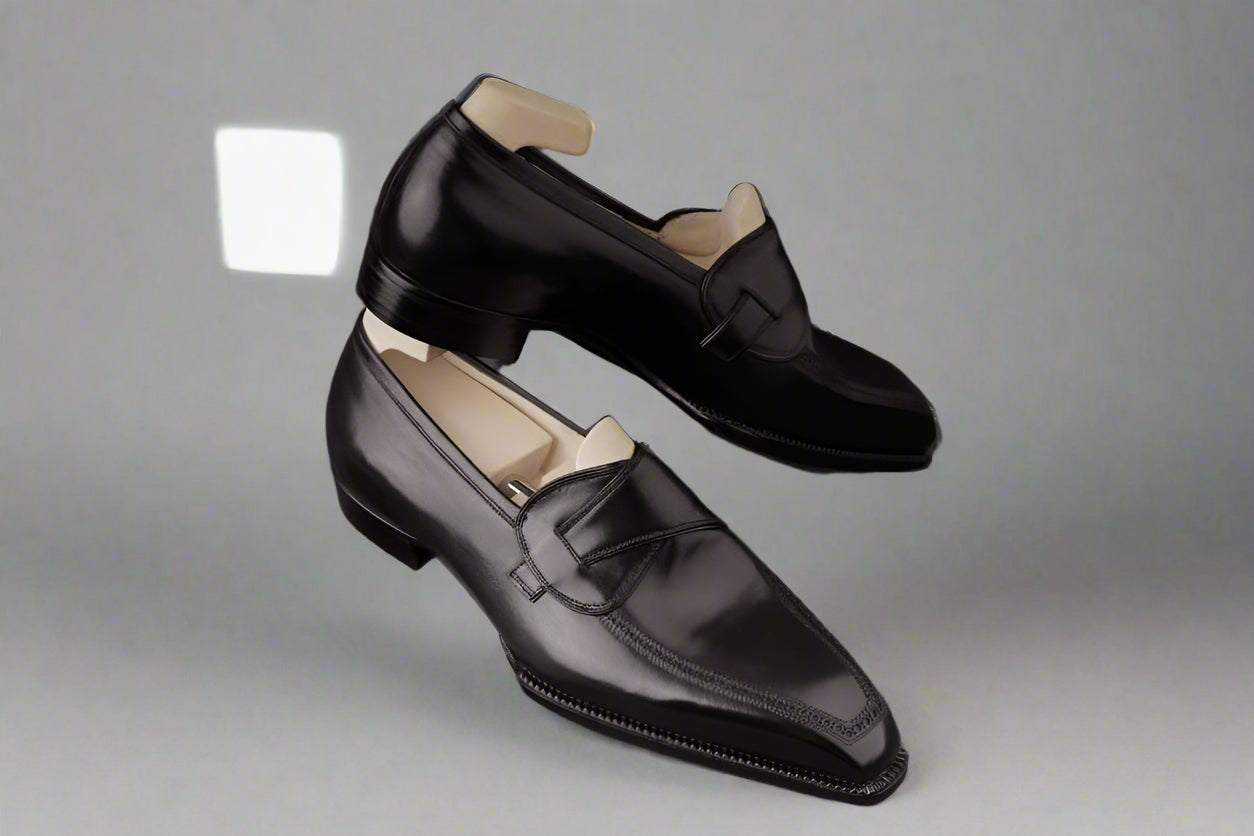 Black loafers on a gray fabric background