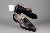 Black loafers on a gray fabric background
