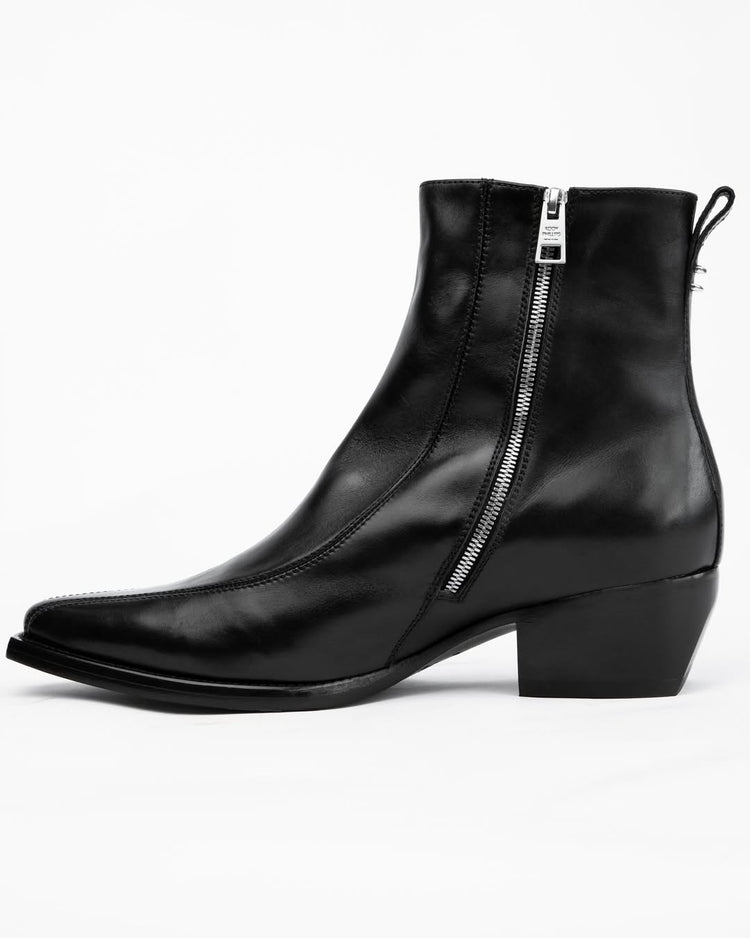 A black leather ankle boot with a side zipper, low block heel, and pull tab, shown from a side profile on a white background.