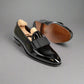 Black patent leather shoes with a wooden insole on a white background