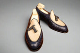 Pair of navy blue loafers with bow details on a wooden surface