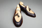 Pair of navy blue loafers with bow details on a wooden surface