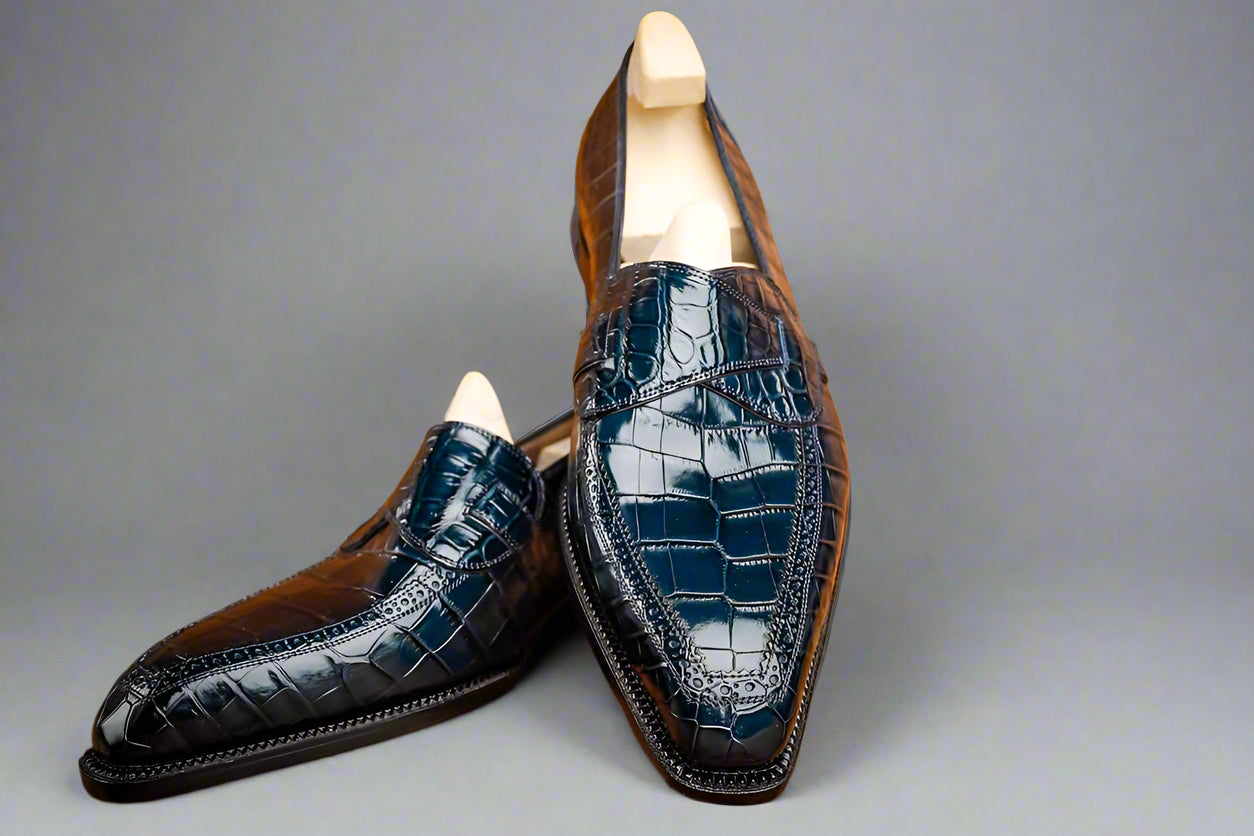 Pair of navy blue dress shoes on a wooden surface