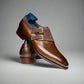 Brown leather shoes with gold buckles on a white background