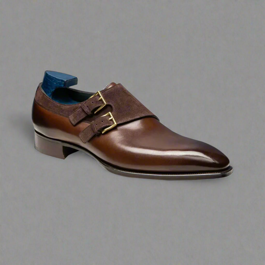 Brown leather dress shoe with gold buckle on a white background