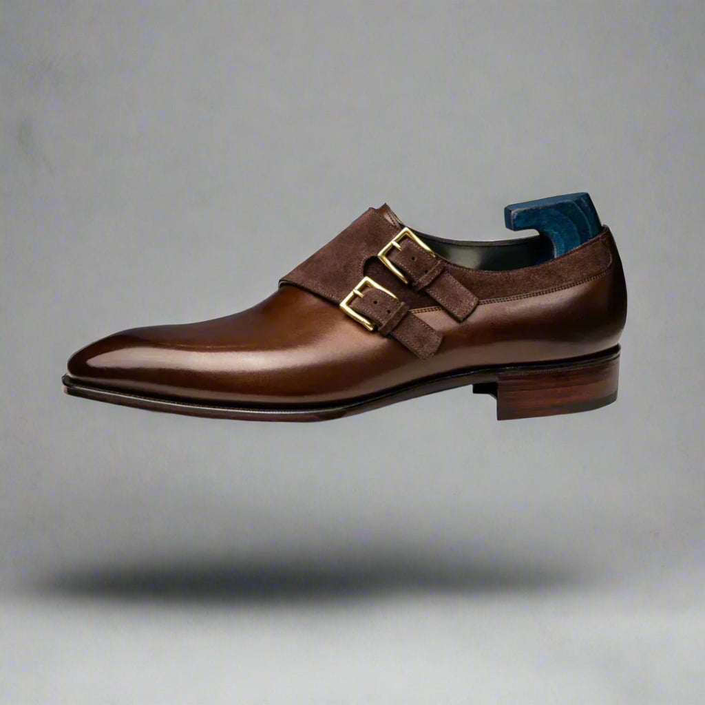 Brown leather dress shoe with gold buckle on a white background