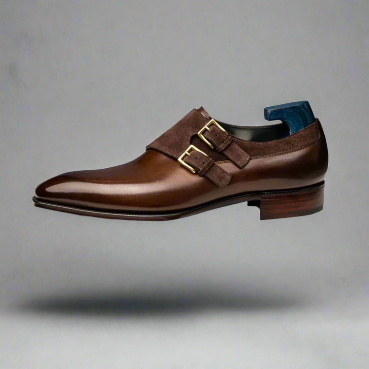 Brown leather dress shoe with gold buckle on a white background