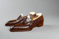 Brown leather loafers on a wooden surface