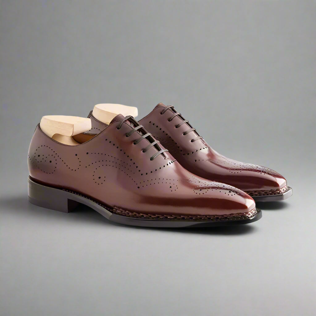 Pair of brown leather dress shoes on a white background