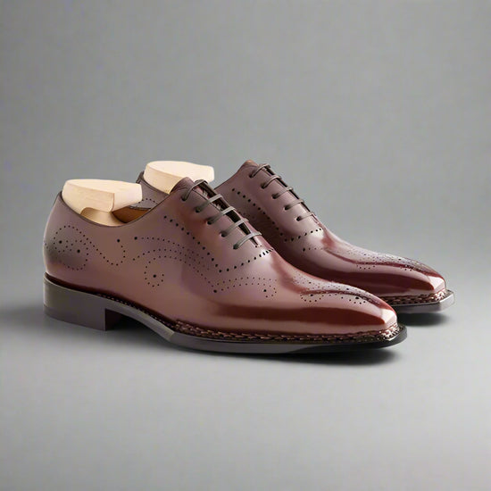 Pair of brown leather dress shoes on a white background