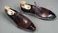 Brown dress shoes with wooden soles on a white surface