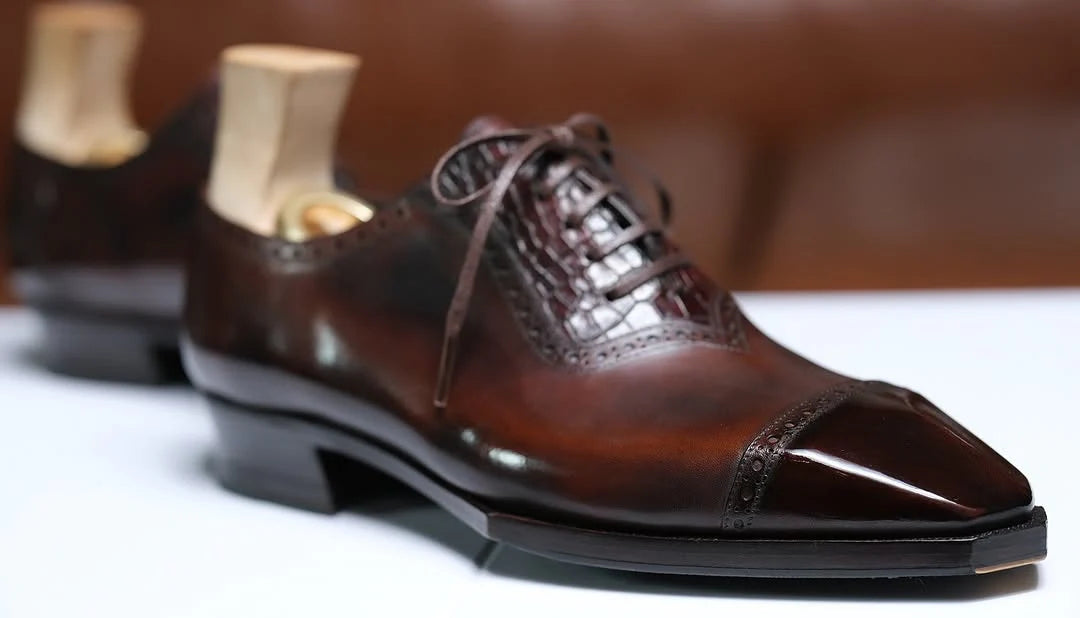 Brown dress shoes with open-toe design on a white surface
