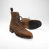 Brown leather boots with black soles on a white background