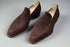 Pair of brown suede loafers on a textured surface