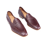 A pair of burgundy leather penny loafers with a square toe and low stacked heel, shown on a plain white background.