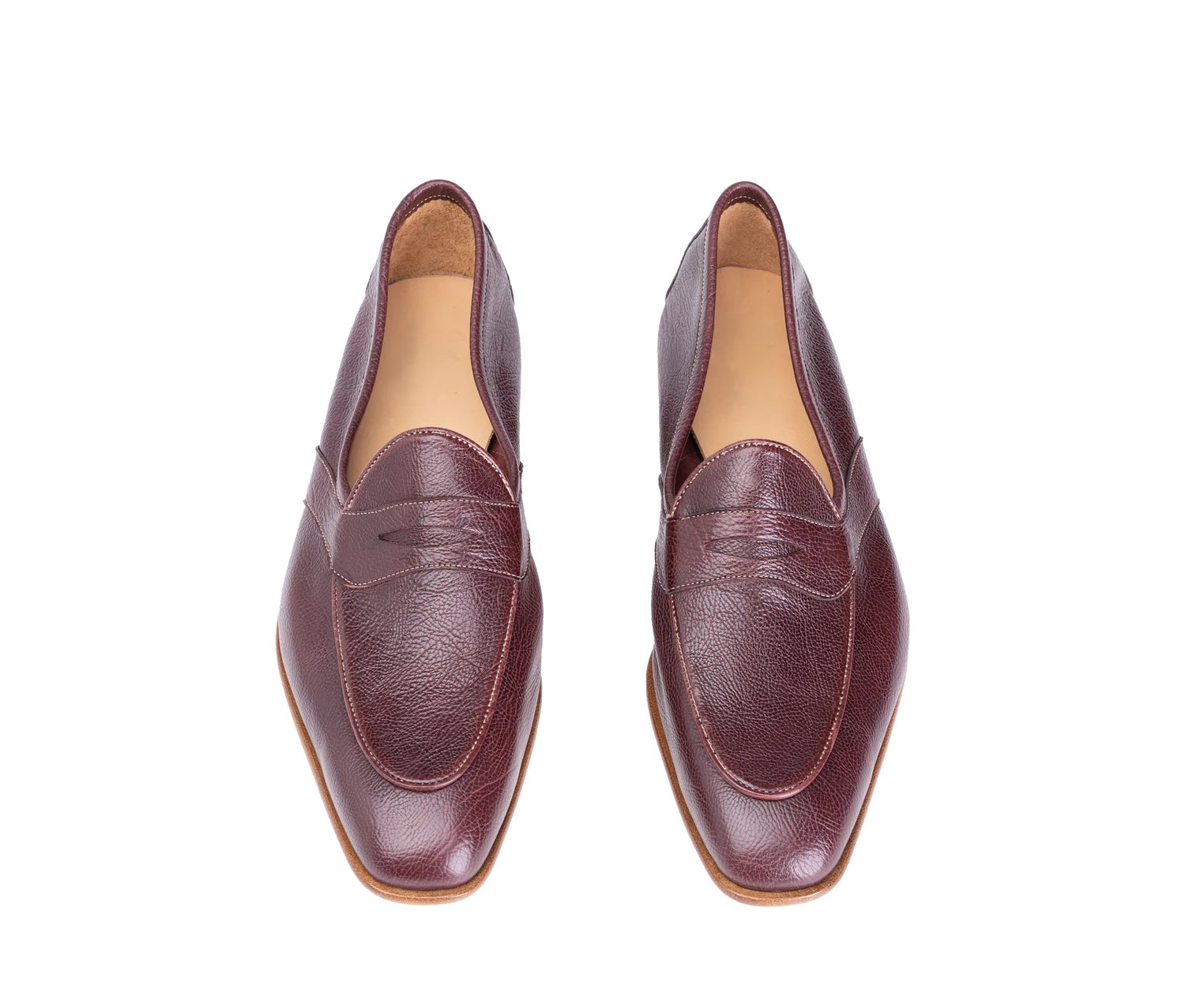 A pair of burgundy leather penny loafers with a pointed toe, shown from a top-down view on a white background.