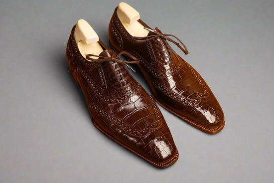 Pair of brown dress shoes on a wooden surface