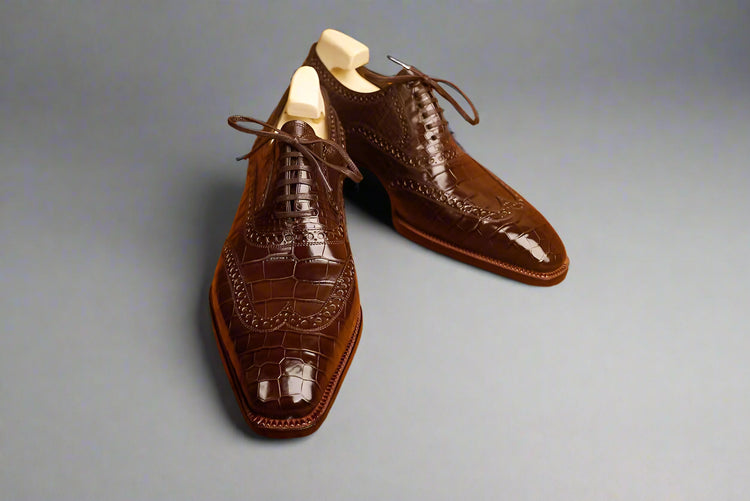 Brown leather dress shoes on a wooden surface