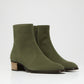 Pair of green ankle boots on a white background