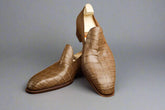 Pair of brown leather shoes on a wooden surface