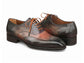 Pair of brown leather dress shoes with orange laces on a white background