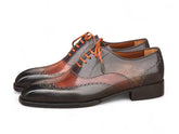 A pair of men's wingtip oxford shoes featuring a dark brown and reddish-brown brogue design with contrasting orange laces, shown on a plain white background.