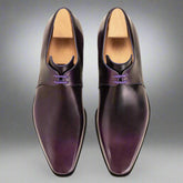 Pair of purple dress shoes with wooden soles on a white background