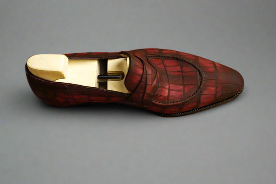 Red leather shoe with a wooden sole on a wooden surface