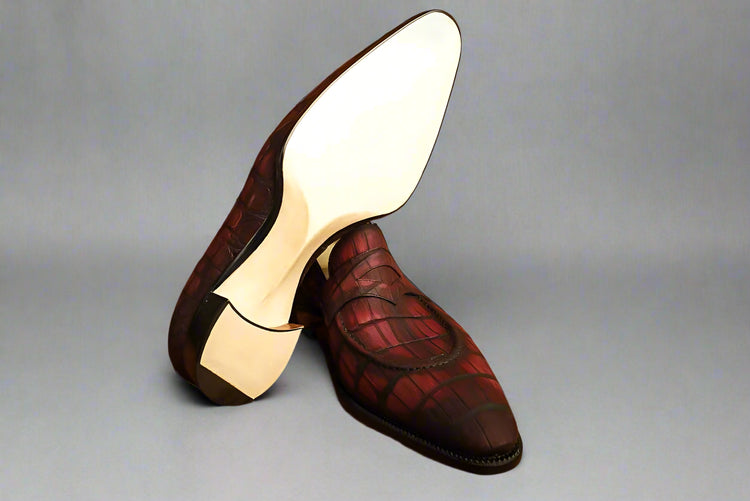 Red and brown dress shoes on a wooden surface