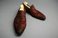 Pair of maroon loafers on a wooden surface