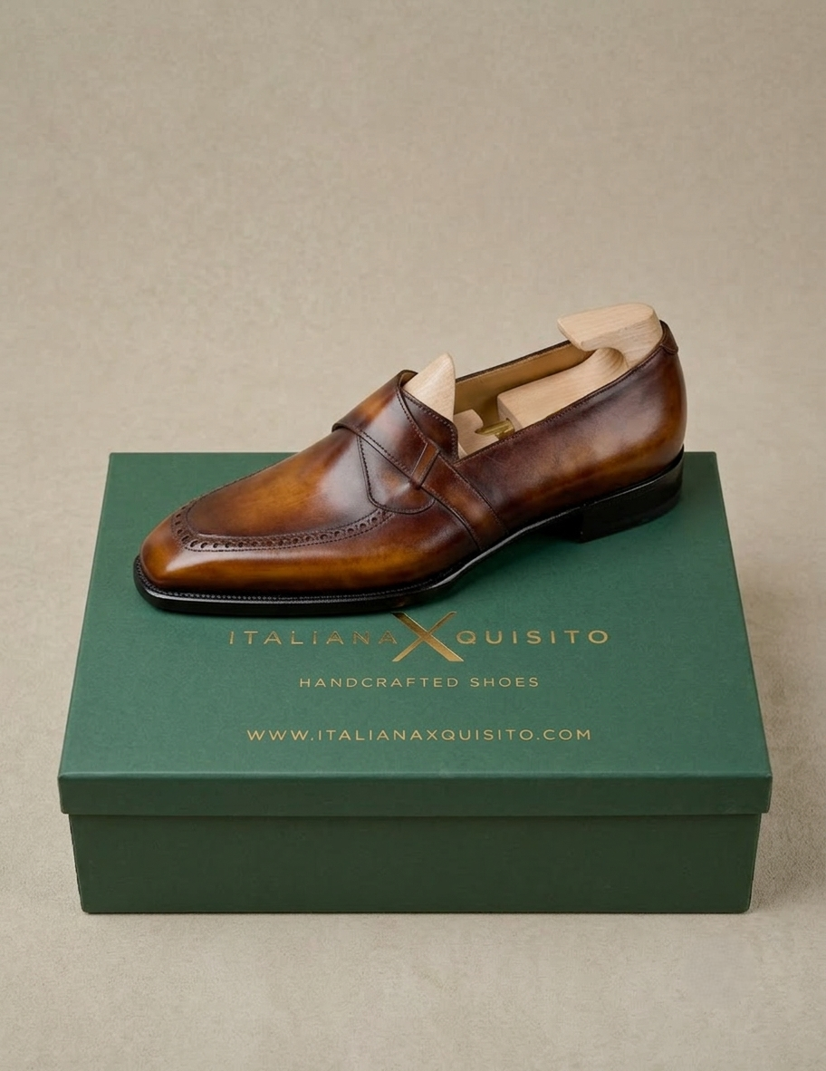 A single brown leather loafer shoe with a tan insole, displayed on top of a dark green shoebox with the brand name 'Italianxquisito' printed in gold.